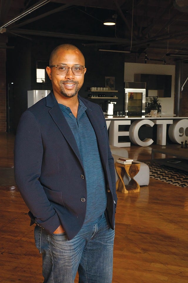 A person with glasses standing posing for the camera